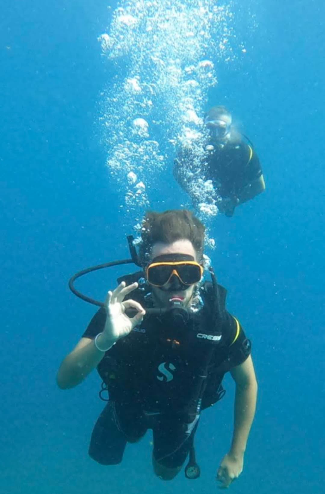 Scuba divers giving the OK sign underwater at Pigeon Island, Trincomalee, Sri Lanka
