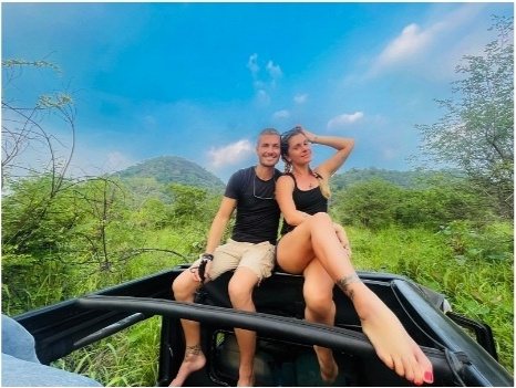 Two safari guests sitting on the open roof of a Pigeon Island Tours jeep in Minneriya